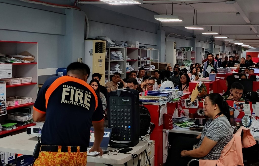 BFP officer in Bureau of Fire Protection shirt presenting fire safety orientation to Nonpareil employees at desks