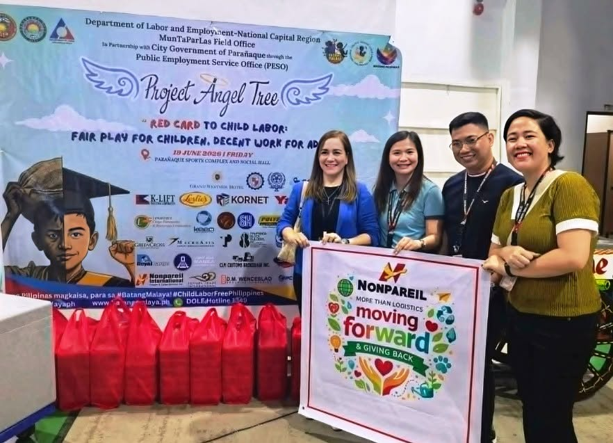 Nonpareil representatives pose in front of the Project Angel Tree event banner