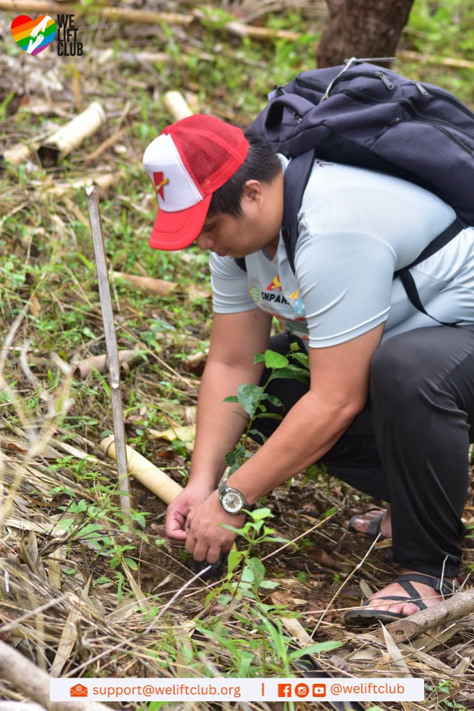 Nonpareil volunteer securing a sapling in the ground during tree planting